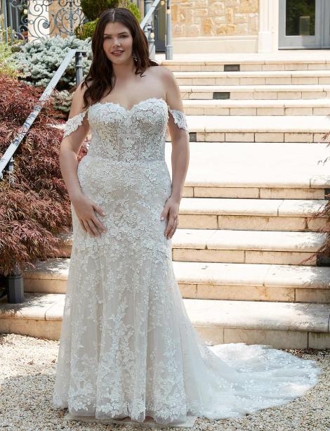 Plus Size model wearing a beautiful wedding dress in front stone steps.