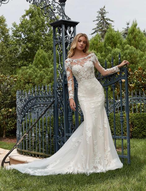 Model wearing a wedding dress in front of a rought iron fence