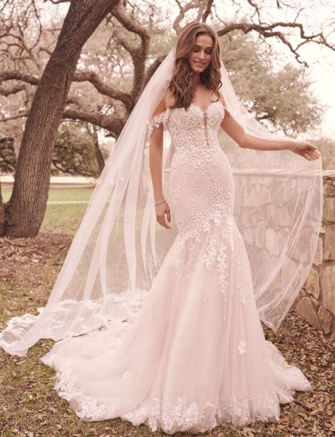 Model wearing a dreamy flowing wedding dress in font of a cherry tree