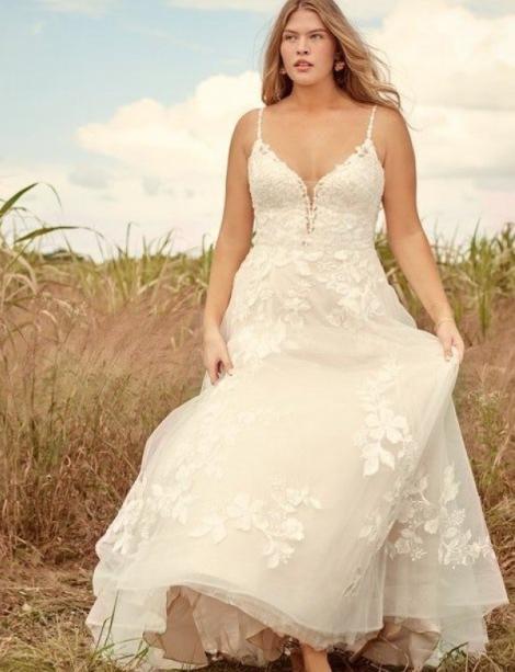 Happy Plus Size model wearing a wedding gown in a wheat field.