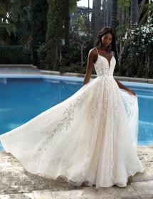 Black model wearing a beautiful wedding dress in front of a pool