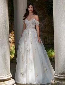 Model wearing a wedding dress in between large white pillars