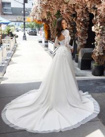 Plus size model wearing a stunning wedding dress on a path with who knows what in the background.