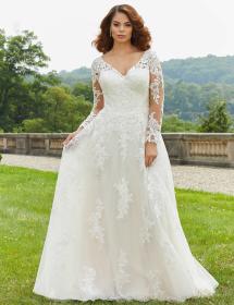 Plus size model wearing a stunning wedding dress in a garden.
