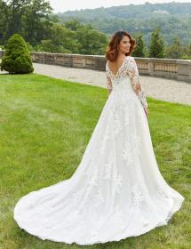 Plus size model wearing a stunning wedding dress on grass on a hillside garden area