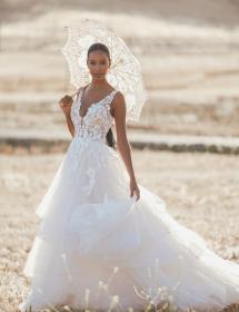Model with a dainty sun umbrella is modeling a wedding dress in the middle of somewhere