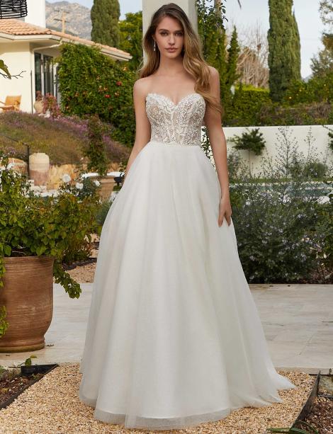 Plus size model wearing a beautiful wedding dress in a garden walkway.