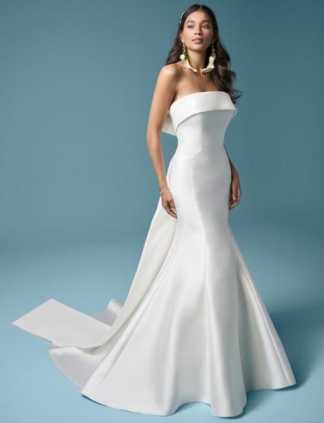 Model wearing a nice elegant white wedding dress in front of bluish background