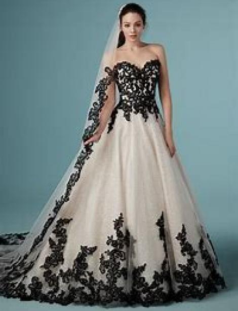 Women with black hair models a dramatic two tone black and white wedding dress. Gown goes well with tatoos. 