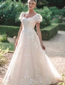 Model wearing a beautiful wedding dress in a garden area.
