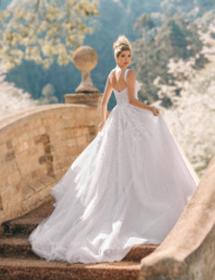 Model looking back wearing a wedding dress on an ornate walking bridge.