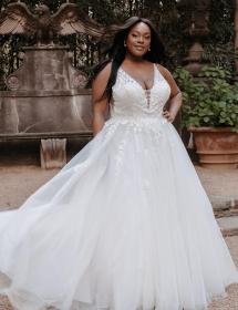 Happy Plus Size Black model wearing a wedding gown in front of a fountain with an eagle.