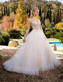 Women looks to her left (your right) while strutting around a palatial garden in a wedding dress.
