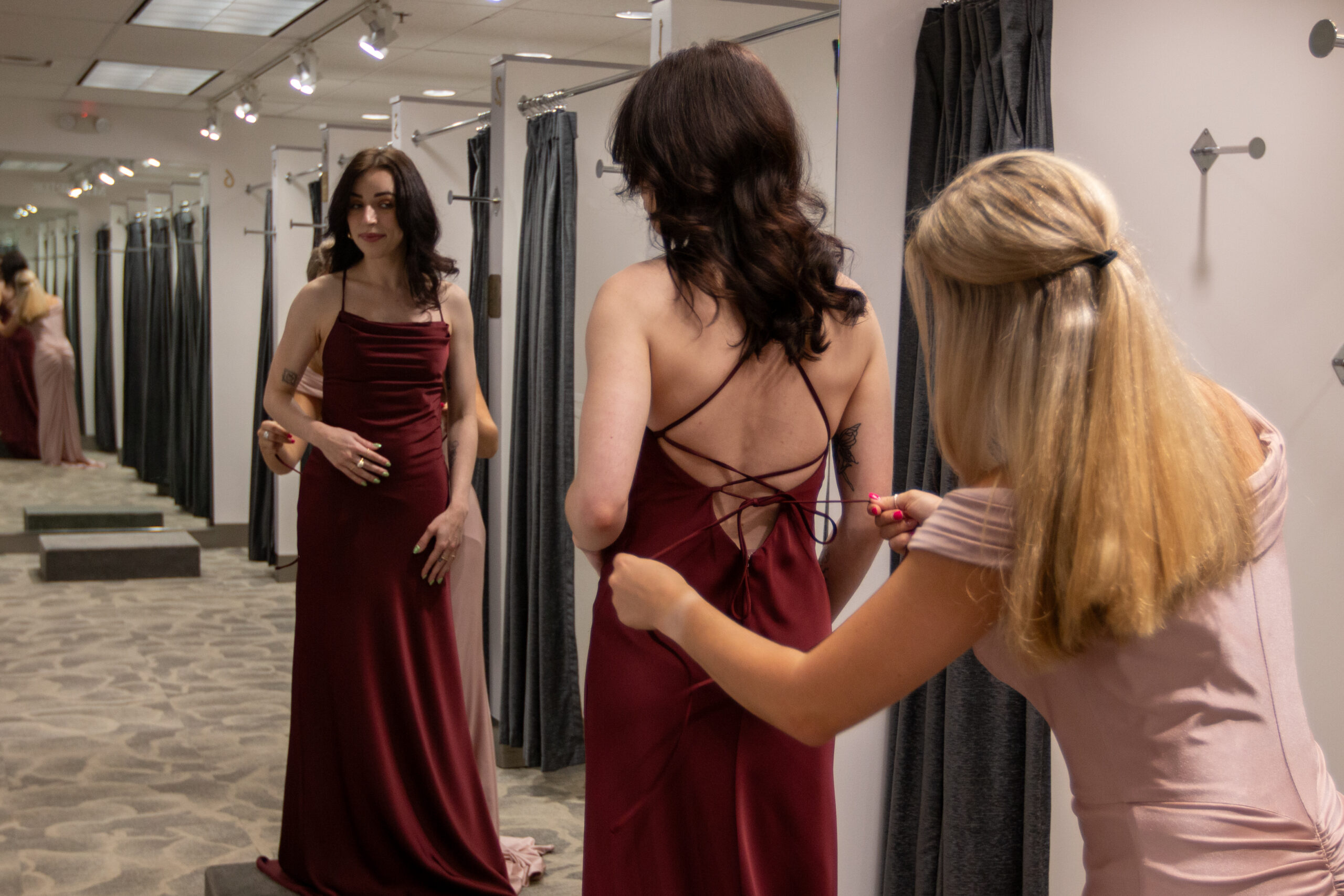 Picture of two bridesmaids helping each other in MB Bride's massive bridesmaids collection.